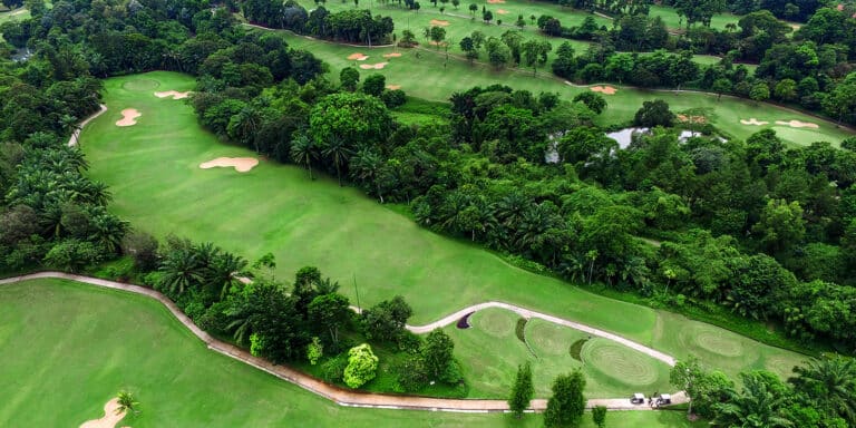 Old Course 2 - aerial view of a lush green golf course with tree-lined fairways, sand bunkers, winding paths, and water features, all nestled within dense forested areas—an inviting landscape for any golf club enthusiast.